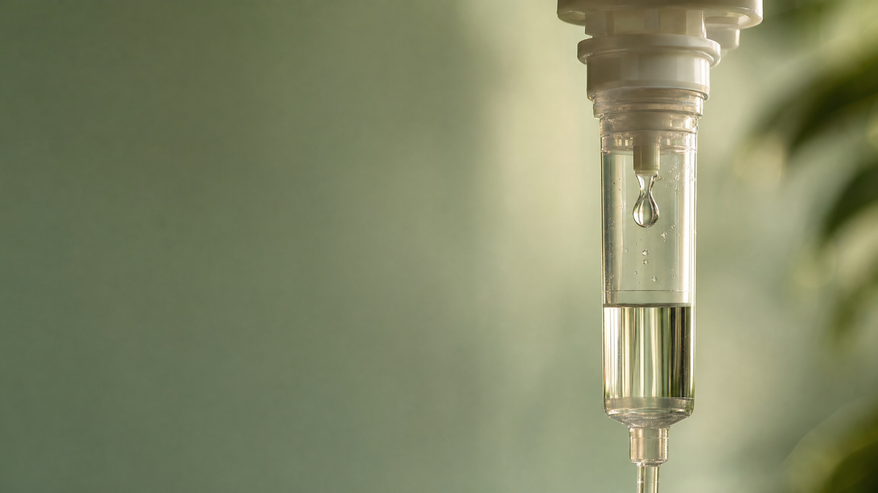 Close-up of an IV drip chamber with a forming droplet